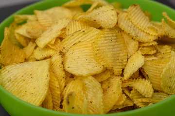 crispy potato chips in a green cup close-up