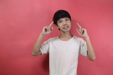 Portrait of young man who is thinking about finding ideas. Asian men wearing white t shirts isolated on a red background