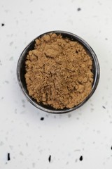 guarana powder in a black cup on a white marble board.View from above.Super food.Portion of Guarana Powder. Useful product. Healthy eating concept. Natural energetic.