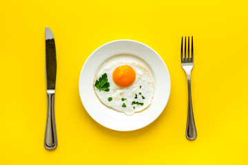 Fried eggs on plate - yellow table top view