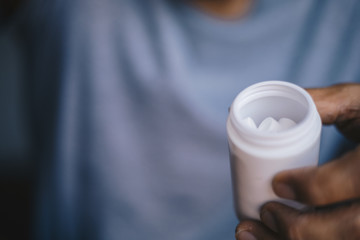close up hand hold medicine bottle 