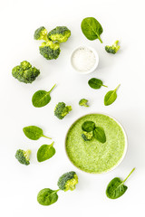 Broccoli and spinach cream soup on white desk from above. Vegetable pattern