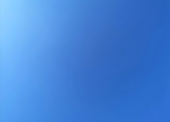 Obraz premium blue sky background with white flare on the sky. Blue color gradian background.