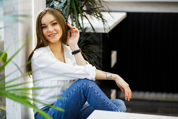 Fototapeta premium Smiling young woman at the cafe with headphones listening to music