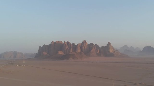 Israel Aerial Drone Of Middle Eastern Camel Owners In Desert Convoy Tourism. Flying View Edom Mountains Arava Rocky Desert with Sand sandy desert and clouds. kibbutz in southern Israel