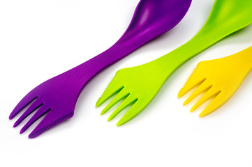 Obraz premium Tourist plastic fork spoon in different colors, photographed large on a white background.