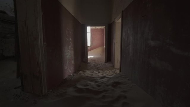 Interior of abandoned house with sand in rooms and corridor - Kolmanskop, Namibia