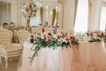 The elegant dinner table. Table set for an event party or wedding reception. Fine restaurant dinner table place setting: napkin, wineglass, plate, bread and flowers.