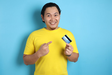 Happy Young Man Smiling and Pointing Credit Card