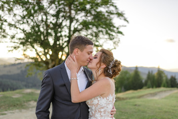Wedding photography in the mountains. The newlyweds kiss. Close-up.