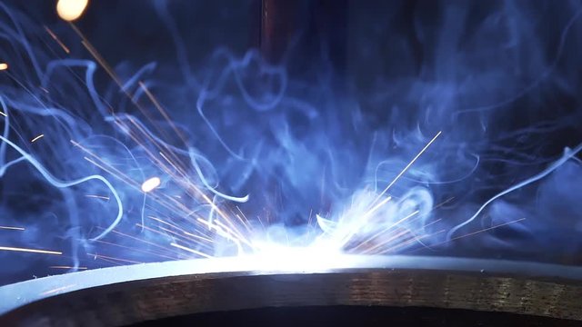 Modern Industrial Robot welding machine active in factory. Automation welding mechanical procedure. Metal iron laser argon welding robot in factory. Automation of work. Slow motion