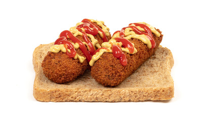 Brown crusty dutch kroket with mustard topping isolated, on a piece of bread
