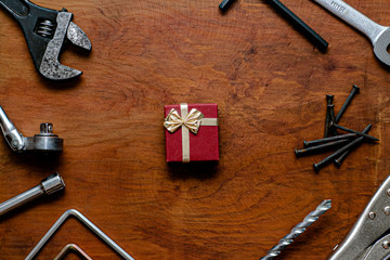 Caja de regalo roja con herramientas al costado