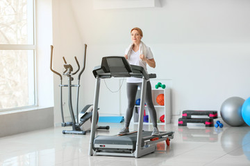 Sporty woman training on treadmill in gym