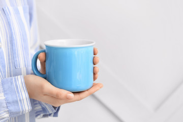 Woman with cup of tea on grey background, closeup