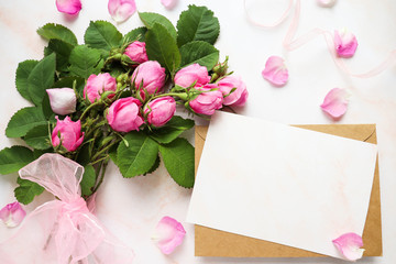 postcard mockup. delicate bouquet of pink roses and an envelope. place for text. invitation. congratulation. flat lay