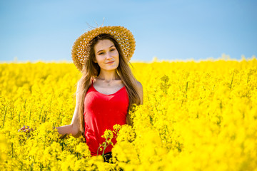 Young woman in blooming rapeseed field in spring.