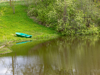 a beautiful river bank in the spring and a lonely boat