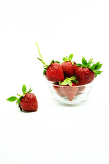 Fresh strawberries in a bowl. Fresh juicy strawberries with powdered sugar in glass bowl isolated on white background.