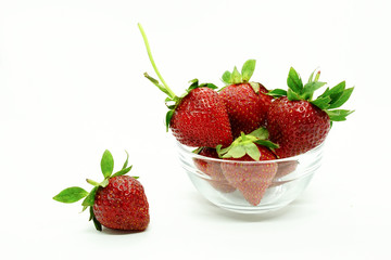 Fresh strawberries in a bowl. Fresh juicy strawberries with powdered sugar in glass bowl isolated on white background.