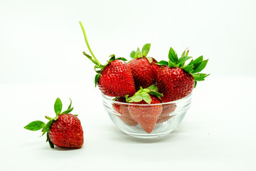 Fresh strawberries in a bowl. Fresh juicy strawberries with powdered sugar in glass bowl isolated on white background.