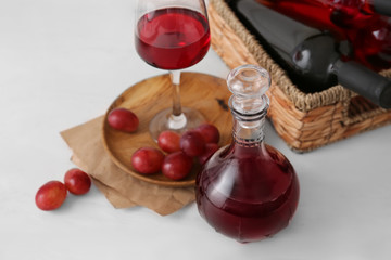 Decanter with glass of wine on white wooden background