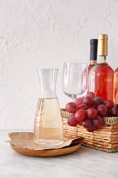 Decanter with bottles of wine on white background