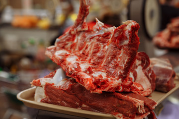 Raw meat on the counter in the market lies on a tray. Close-up. Shallow depth of field. Blurred background.