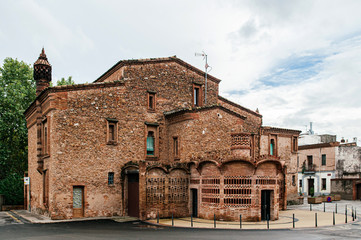 Fototapeta premium Red brick vintage building of Ca l'Ordal in La Colonia Guell in Barcelona, Spain.