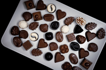 Traditional Turkish Candies designed on black surface with chocolate.Conceptual image of celebrations. Close-up chocolate. Religious Holiday, The Sugar Feast After Ramadan. Top view.
