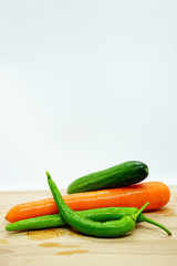 fresh vegetables on a wooden table isolated on white.