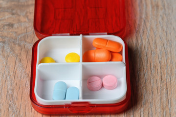 Tablets in a red pill box. Drugs for the treatment of coronavirus. A reminder of taking the pill.