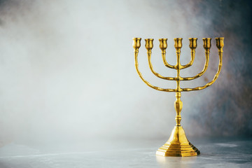Golden hanukkah menorah on grey background. Jewish holiday banner with copy space. Ancient ritual religious candle menorah - obrazy, fototapety, plakaty