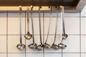 soup spoons, ladles hanging in commercial kitchen