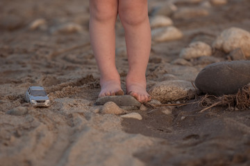 Small children's feet stand on a stone.