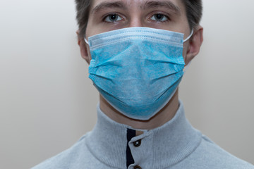 Young man in a medical mask smiles, portrait