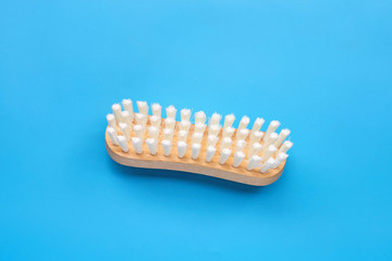 Wooden clothes brush on blue background.