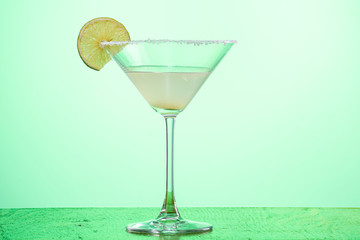 margarita cocktail in martini glass on a light green background