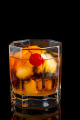 old fashion cocktail in a glass of rox on a black background