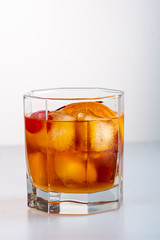 old fashion cocktail in a glass of rox on a white background