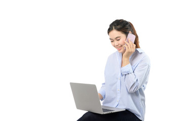 Woman working on laptop while talking on phone, warm light