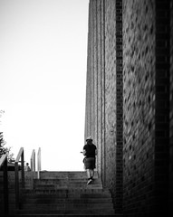 Man walking upstairs in street playing a ukulele.