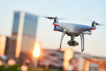 drone with digital camera flying at city street