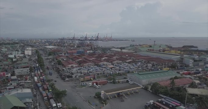 Ungraded, Ascending aerial flight over poor housing area next to harbour. Drone, 4K. 