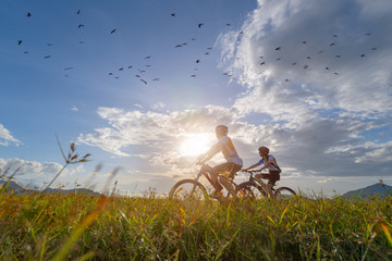 family couple lover enjoy the life of riding biking on the fresh field meadow grass, cheerfully life holding hand together on outdoors activity