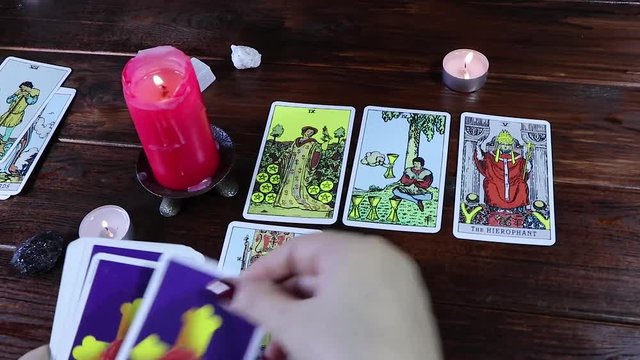 A Gypsy fortune-teller plays solitaire and reads Tarot cards by candlelight. Predictions of fate and a magical session on the cards