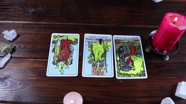  Gypsy fortune-teller plays solitaire and reads Tarot cards by candlelight. Predictions of fate and a magical session on the cards