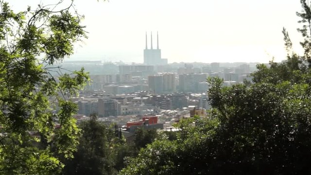 Vista panor&aacute;mica de la ciudad de Barcelona desde un parque. Vista de la famosa f&aacute;brica de las 3 chimeneas y el Mar Mediterr&aacute;neo de fondo