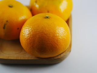 three orange on wooden plate in white background 
