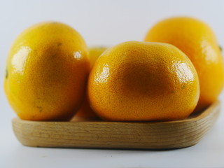 Four orange in wooden plate on white background